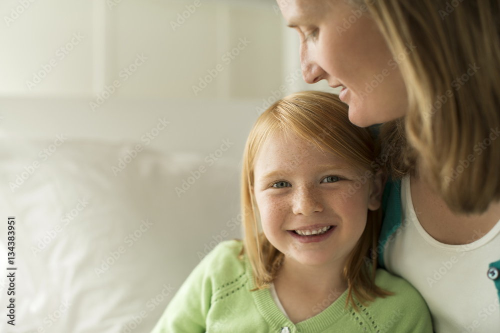 Portrait of a smiling young girl sitting with her mother. Portrait of a smiling young girl sitting with her mother.