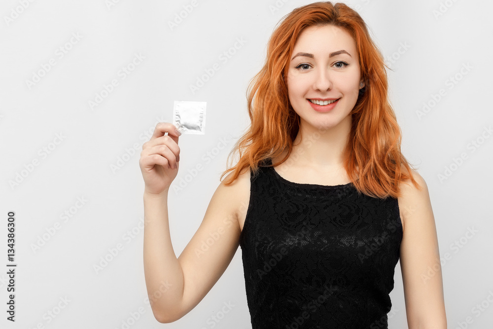 Remember about protection. Safe sex concept. Hand with condom. Contraceptive. Protection against AIDS and birth control. She gives the guy a condom before sex. Remember about protection. Safe sex concept. Hand with condom. Contraceptive. Protection against AIDS and birth control. She gives the guy a condom before sex.