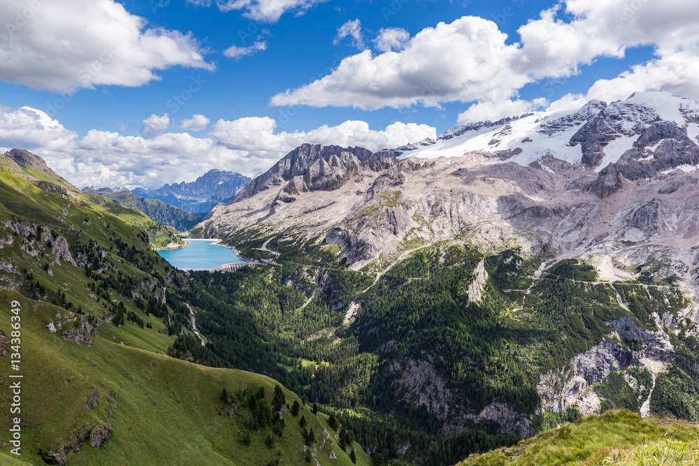 View of the Marmolada, also known as the Queen of the Dolomites and the Fedaia Lake. Marmolada is the highest mountain of the Dolomites, situated in northeast of Italy.