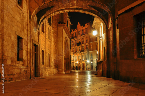  Spain. Valencia. Night cityscape in the historical streets.  Old town, narrow street at night. Mysterious alley with arch and with lanterns.  photo