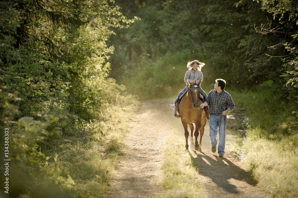 Mature man leading his daughter on a horse. Mature man leading his daughter on a horse.