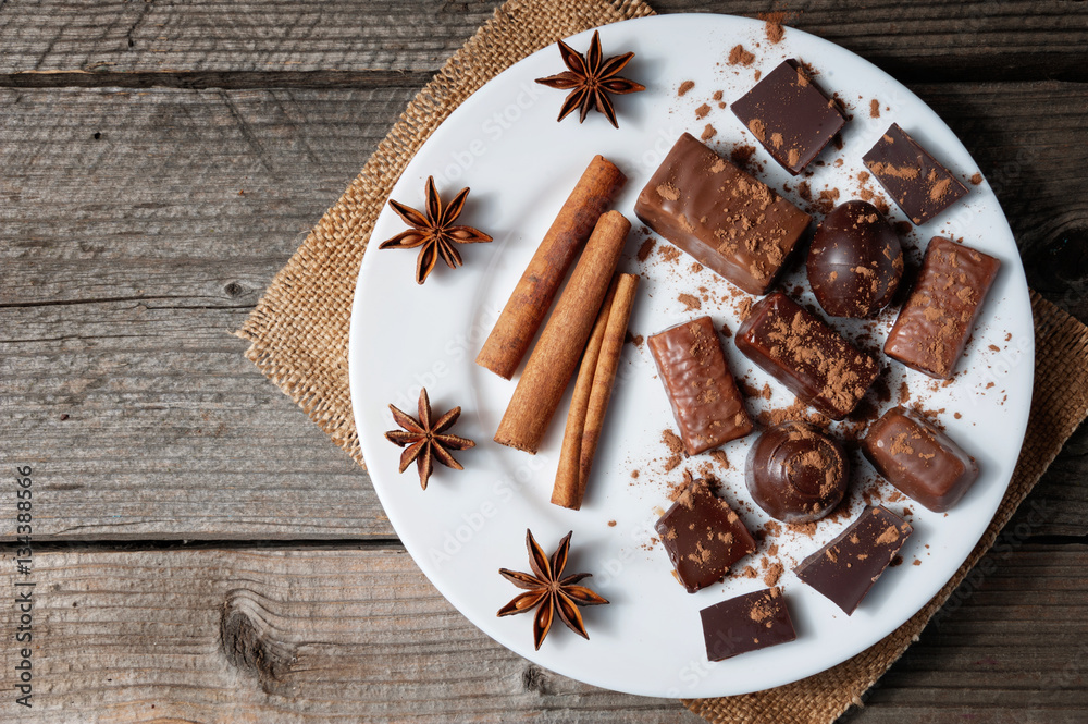 Pieces of chocolate with cinnamon and star anise on table Pieces of chocolate with cinnamon and star anise on table