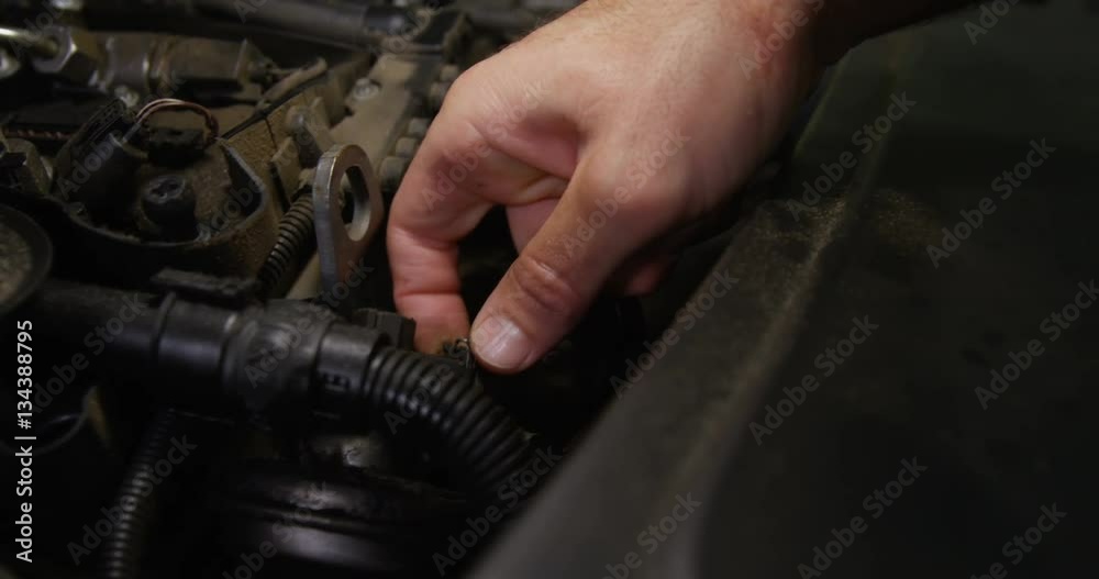 Hands of mechanic checking a car engine in garage 4k Hands of mechanic checking a car engine in garage 4k
