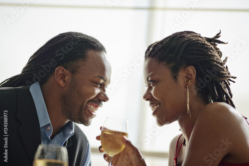 Happy young couple gazing into each other's eyes as they enjoy a romantic dinner. photo