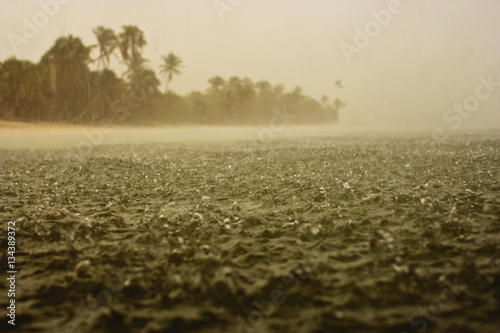Hard rain splashing on the surface of the sea near a tropical island. photo