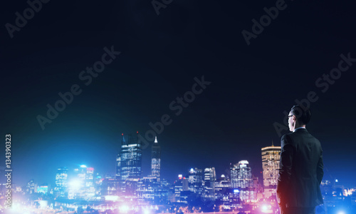 Businessman viewing night glowing city