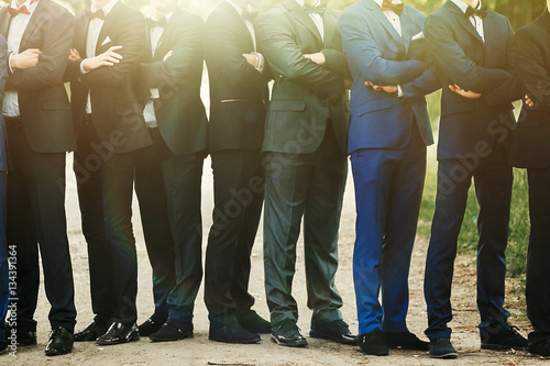 stylish confident men in suit standing posing, reception at luxu photo