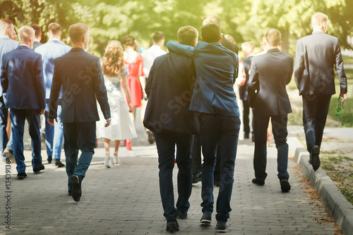 Foto stylish confident man in suit having fun, group of people walkin