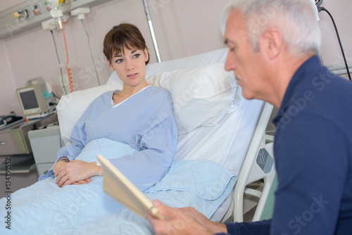man reading to patient in hospital