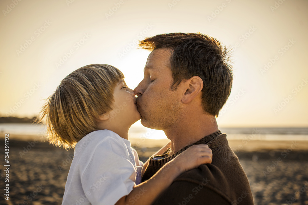 Father kissing son at the beach Stock Photo | Adobe Stock