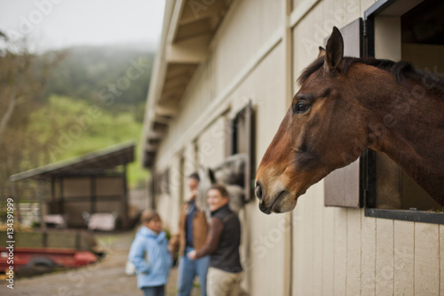 Family standing next to the horse stable