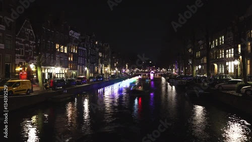 AMSTERDAM, NETHERLANDS - JANUARY 02, 2017: Cruise boat in night canals of Amsterdam. Time Lapse. January 02, 2017 in Amsterdam - Netherland.
