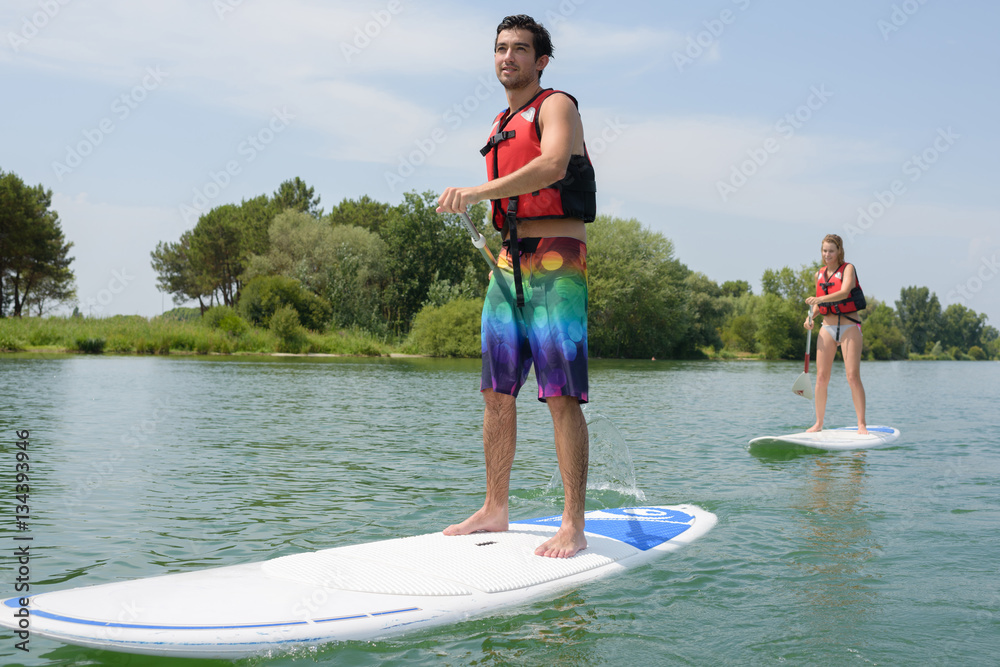 Obraz premium silhouette of perfect couple engage standup paddle boarding