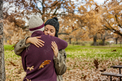 Portrait young couple hugging in a rain of leaves in autumn. Bac