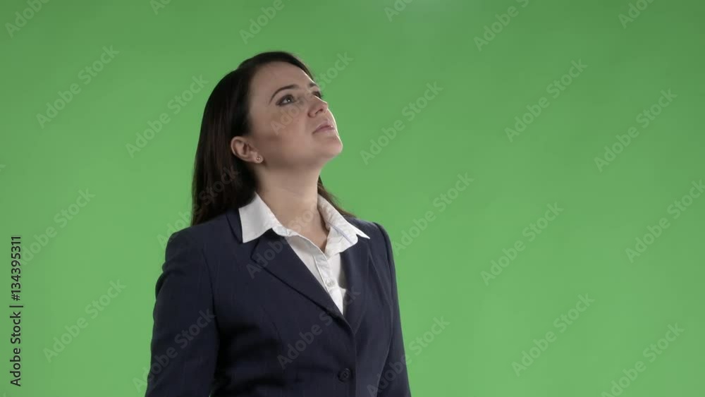  Business woman looking up and checking schedule on departure board against a green screen.