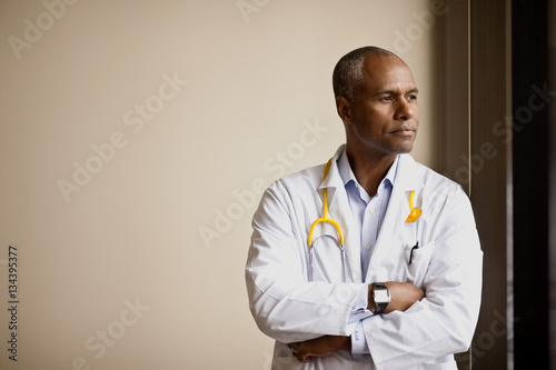 Thoughtful male doctor looking away photo
