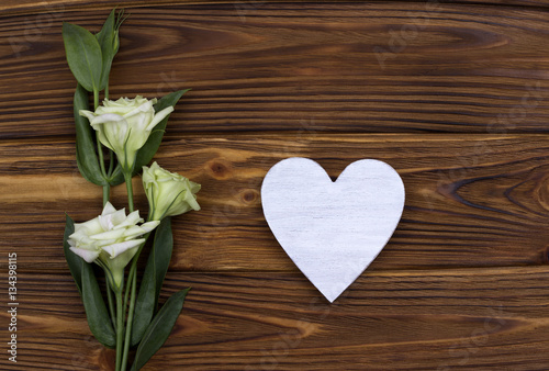 Fototapeta Naklejka Na Ścianę i Meble -  White wooden heart with flowers on brown background. Valentine Day. Greeting Card. Wedding.
