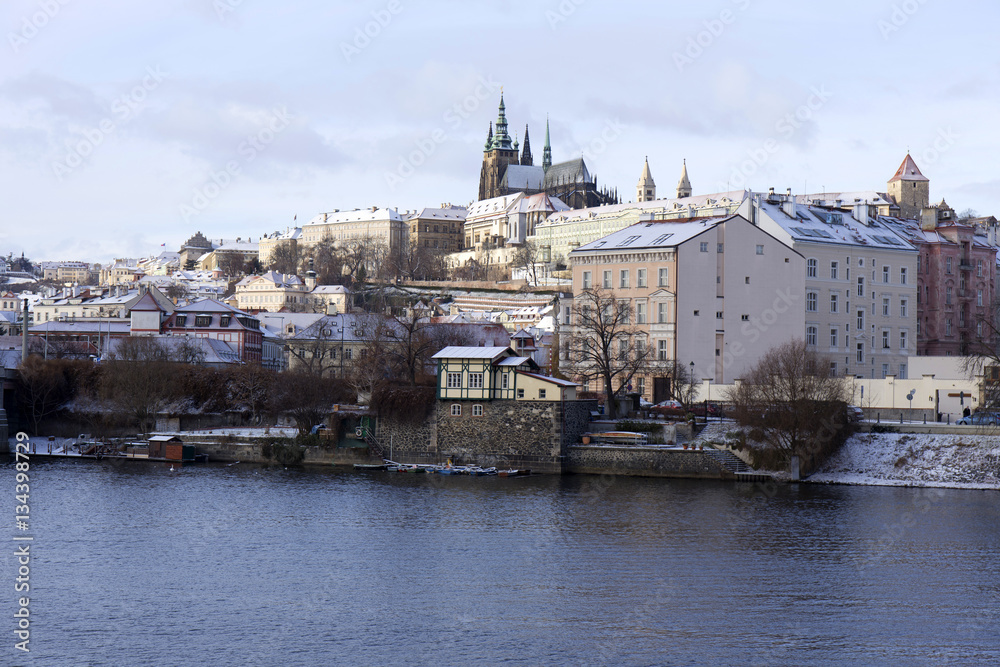 Fototapeta premium Snowy freeze Prague Lesser Town with gothic Castle above River Vltava, Czech republic