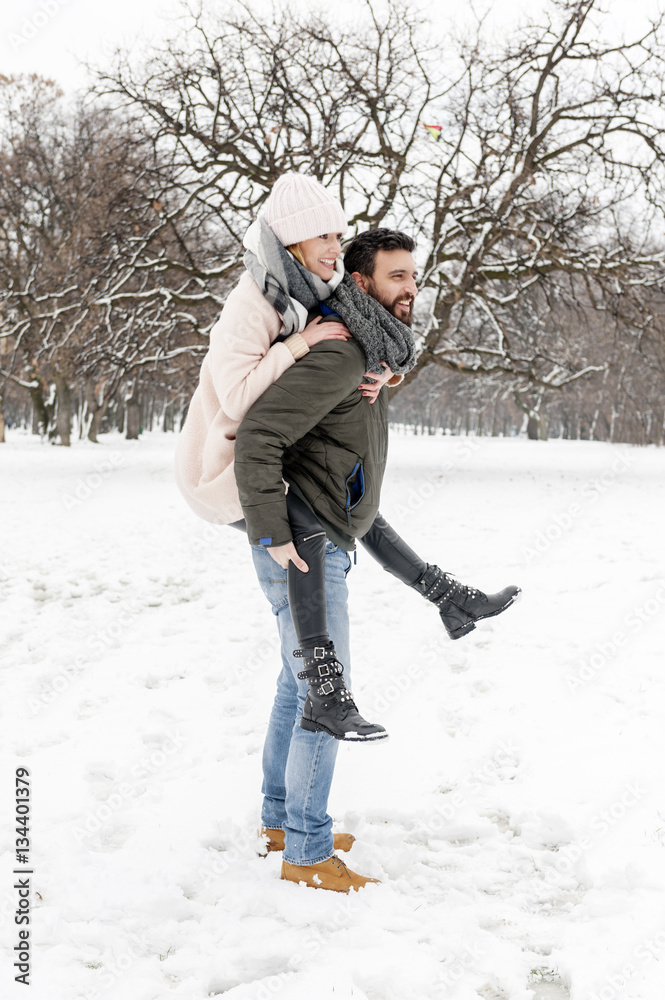 Loving couple enjoying the snow in the park Loving couple enjoying the snow in the park