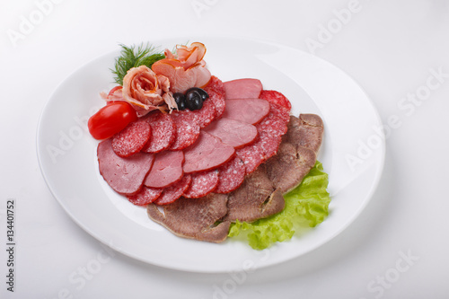 thin slices of sausage and meat on a plate white background