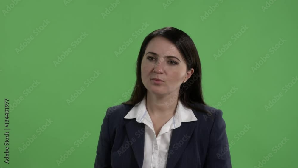 Woman in business suit having conversation with someone against green screen Woman in business suit having conversation with someone against green screen