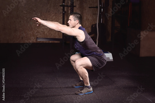 Young handsome man doing sq...