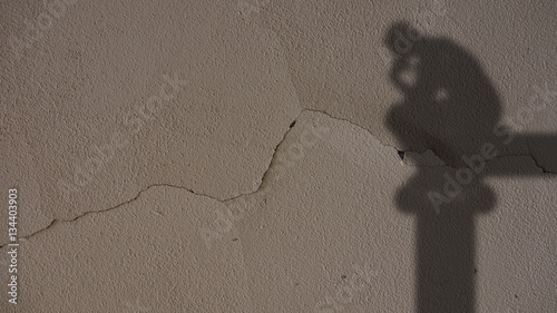 Thinker Shadow on Grey Cracked Concrete Wall