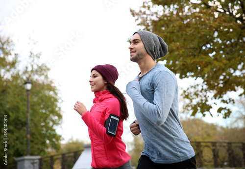 Young couple running in bea...