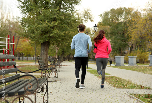 Young couple running in bea...