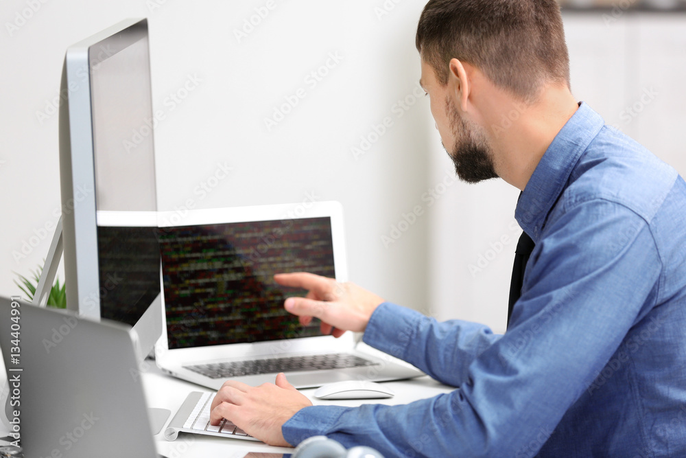 Handsome young programmer working in office Handsome young programmer working in office
