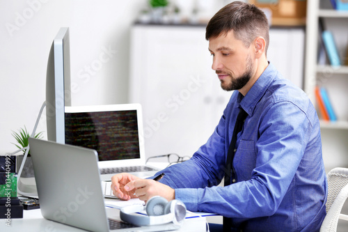 Handsome young programmer working in office