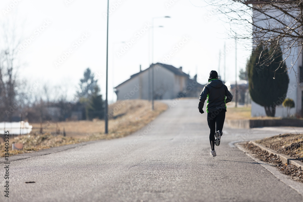 woman running from rear view in winter woman running from rear view in winter