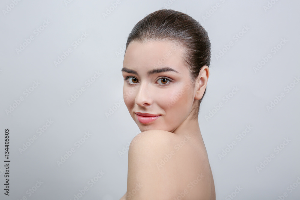 Beautiful young woman on light background