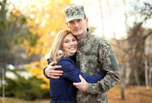 Photography Soldier in camouflage hugging his wife outdoors