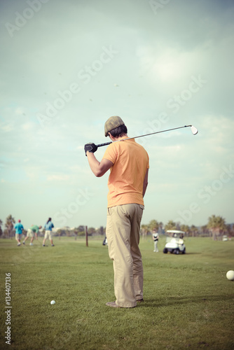 Back view of man on green grass golf field natural outdoors background