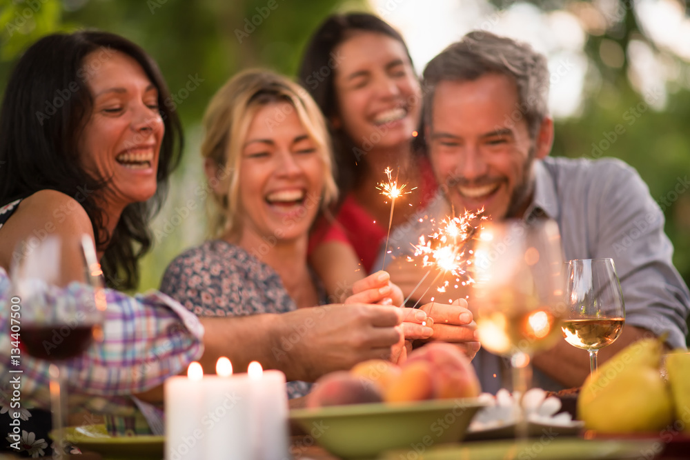 On a terrace friends enjoy themselves by lighting spark sticks