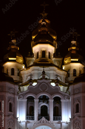 Church of the Holy Myrrh-Bearers of the Mirror stream. Kharkiv. Ukraine. Detailed photo of Church with golden domes and relief decors at night photo