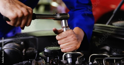 Hands of female mechanic servicing a car in garage 4k