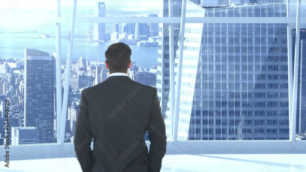 Businessman standing and looking at office window Businessman standing and looking at office window