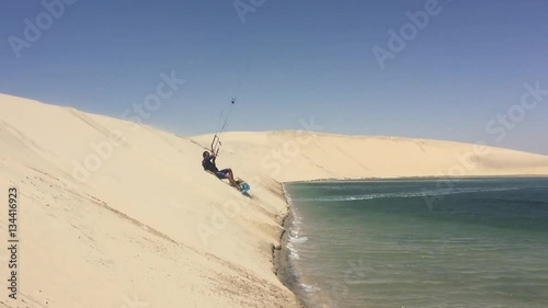 Man practicing kitesurfing on the white dune. Dakhla, Morocco. photo