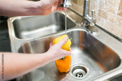 Washing bell peppers in kitchen sink