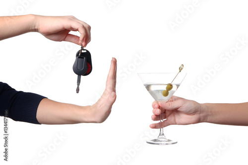 Hand of female driver refusing glass with alcoholic beverage, on white background. Don't drink and drive concept