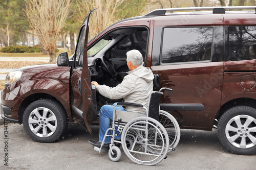 Man in a wheelchair next to his car © Africa Studio