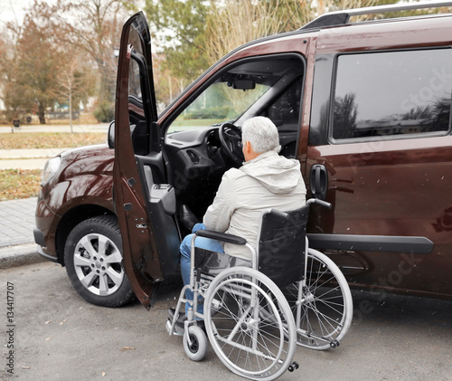 Man in a wheelchair next to his car