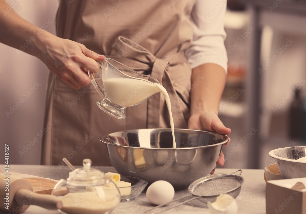 Young woman making dough in kitchen Young woman making dough in kitchen