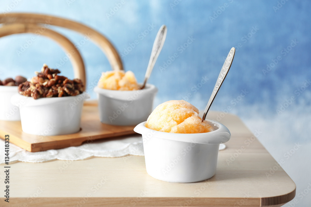 White cups with color ice dessert on wooden table White cups with color ice dessert on wooden table