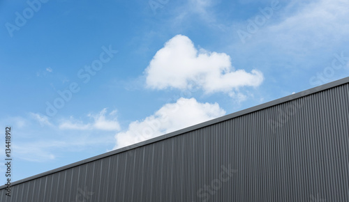 Corrugated factory industry wall on blue sky with clouds  © SasinParaksa