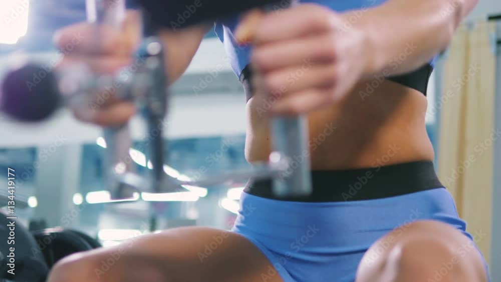 Young attractive female doing sport excercises in gym, close up Young attractive female doing sport excercises in gym, close up