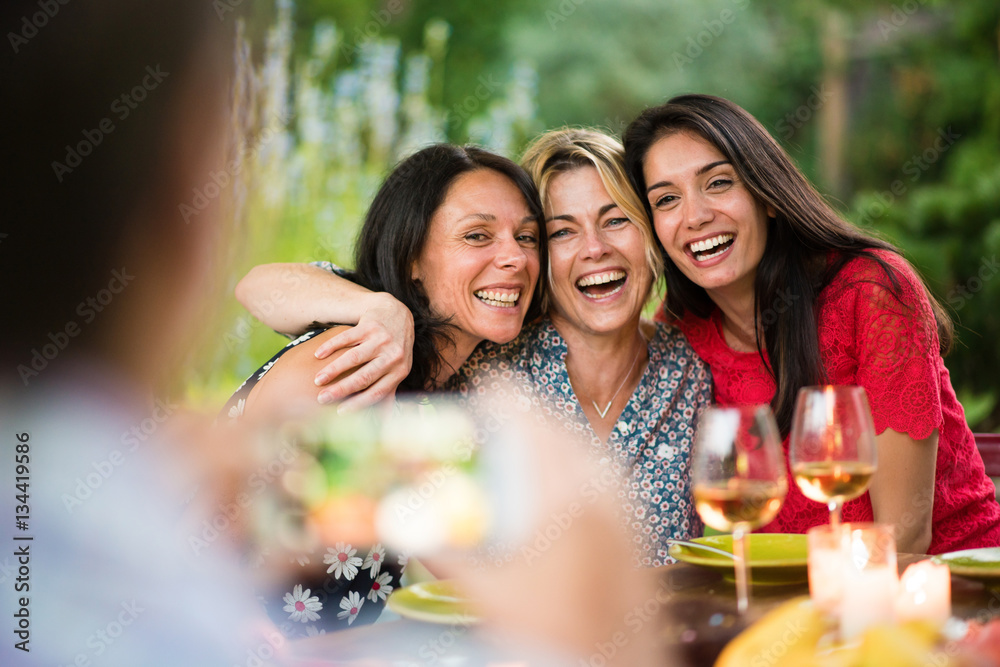 Fototapeta premium Three beautiful women posing for a photo around a terrace table