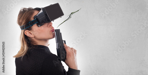 Billede på lærred Woman play VR shooter game with virtual reality gun and vr glass